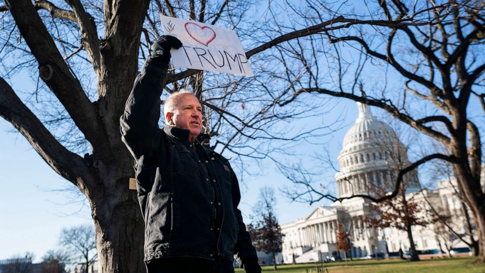 PHOTO: A lone Trump supporter holds a sign in support of the President outside the Capitol in Washington, Dec. 18, 2019.
