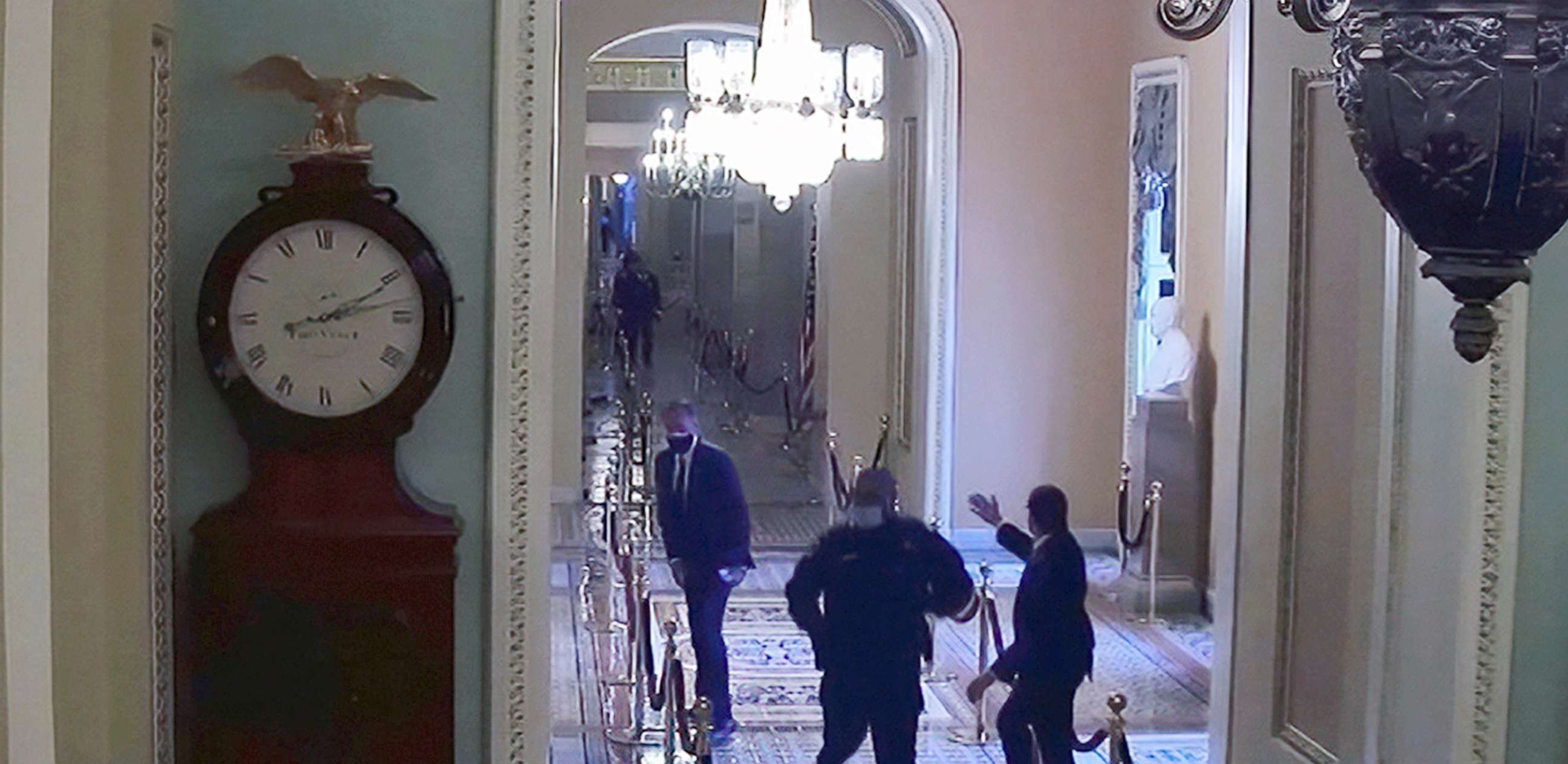 PHOTO: Capitol Police officer Eugene Goodman runs past Sen. Mitt Romney, in security footage from the security breach of the Capitol on Jan. 6, 2021.