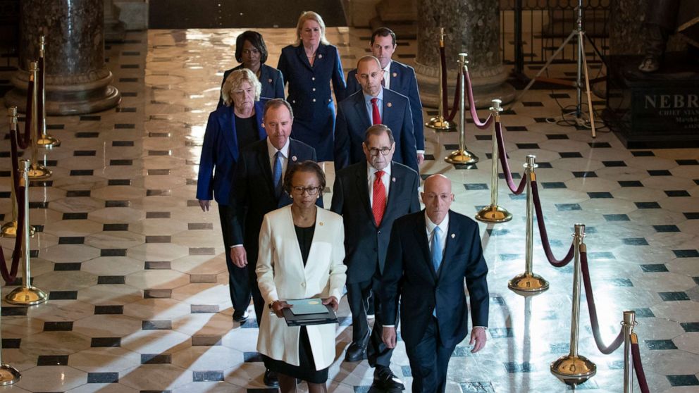 PHOTO: Clerk of the House Cheryl Johnson, left, and House Sergeant at Arms Paul Irving pass through Statuary Hall at the Capitol to deliver the articles of impeachment against President Donald Trump to the Senate, Wednesday, Jan. 15, 2020.