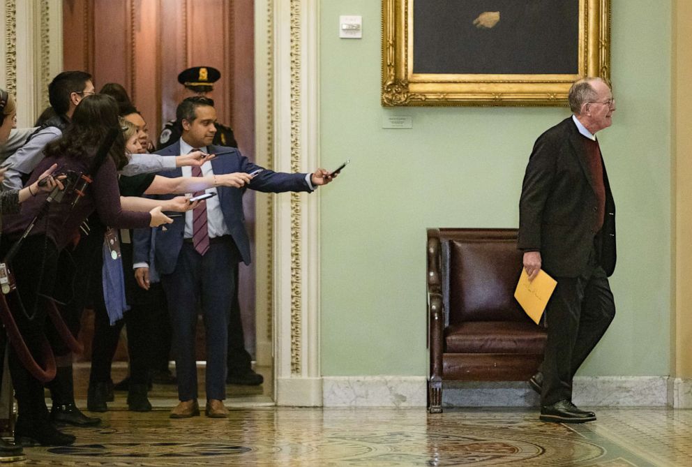 Reporters reach out with their cell phones and audio recorders trying to get a statement from republican Sen. Lamar Alexander as he passes by during a recess in the Senate impeachment trial of President Donald Trump on Jan. 30, 2020, in Washington. 