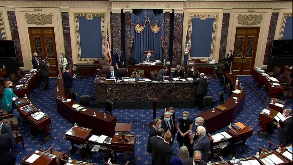 PHOTO: Senate Minority Leader Mitch McConnel huddles with other senators after the Senate voted for witnesses during the fifth day of the impeachment trial of former president Donald Trump in Washington, Feb. 13, 2021.