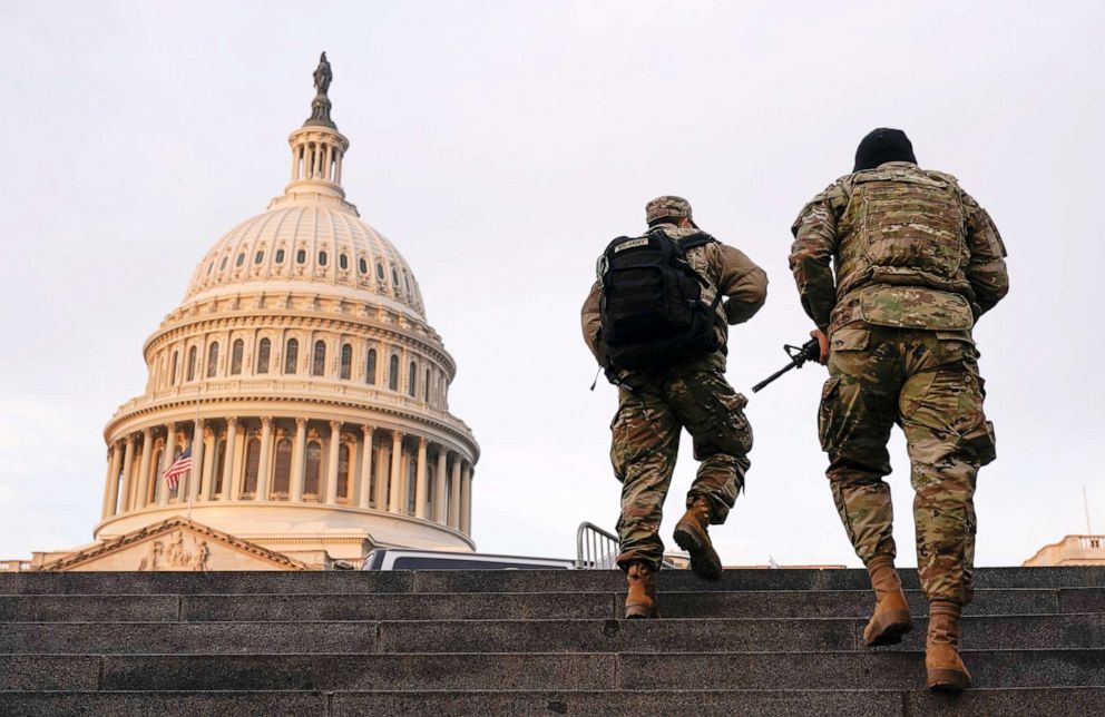 PHOTO: National Guard members walk at the Capitol, in Washington, Jan. 15, 2021.