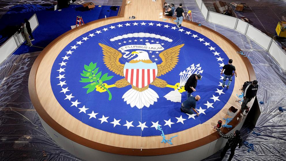 PHOTO: Workers prepare a carpet with the presidential seal for the Commander in Chief Inaugural Ball at the Washington Convention Center, Jan. 18, 2025, in Washington, D.C. 