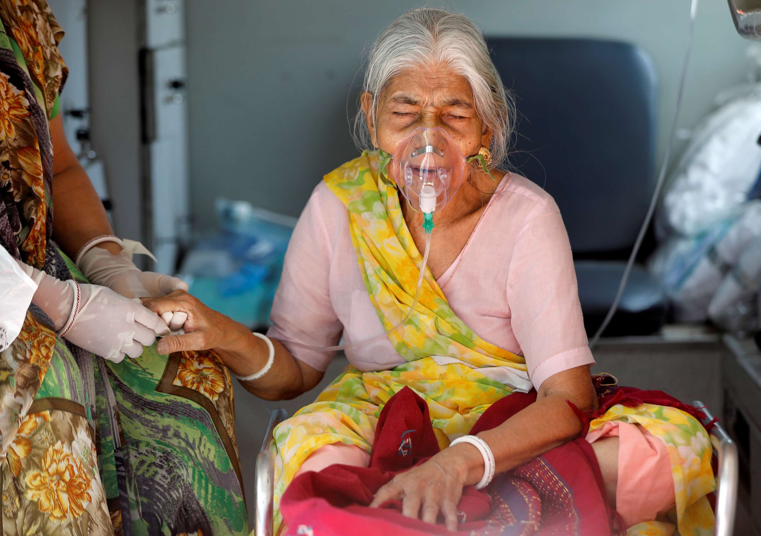 PHOTO:Lilaben Gautambhai Modi, 80, wears an Oxygen mask as she sits inside an ambulance as waiting to enter a COVID-19 hospital for treatment in Ahmedabad, India, May 5, 2021.