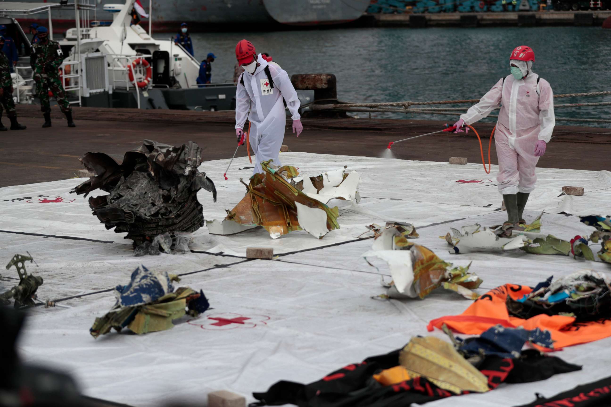 PHOTO: Workers spray disinfectant at parts of aircraft recovered from Java Sea where a Sriwijaya Air passenger jet crashed, at Tanjung Priok Port in Jakarta, Indonesia, Jan. 11, 2021.