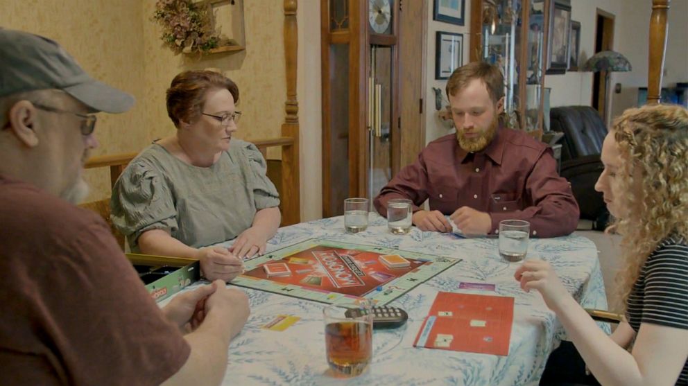 PHOTO: Former FBI informant Dan Day, left, his wife and his two children play a game of Monopoly, August 2021.