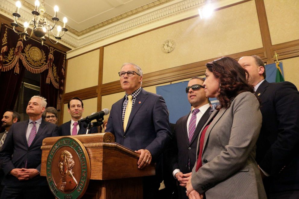 PHOTO: Gov. Jay Inslee, surrounded by Democratic lawmakers from the Senate and House, talks to the media following the Washington Legislature adjourning its 105-day legislative session, April 29, 2019, in Olympia, Wash. 