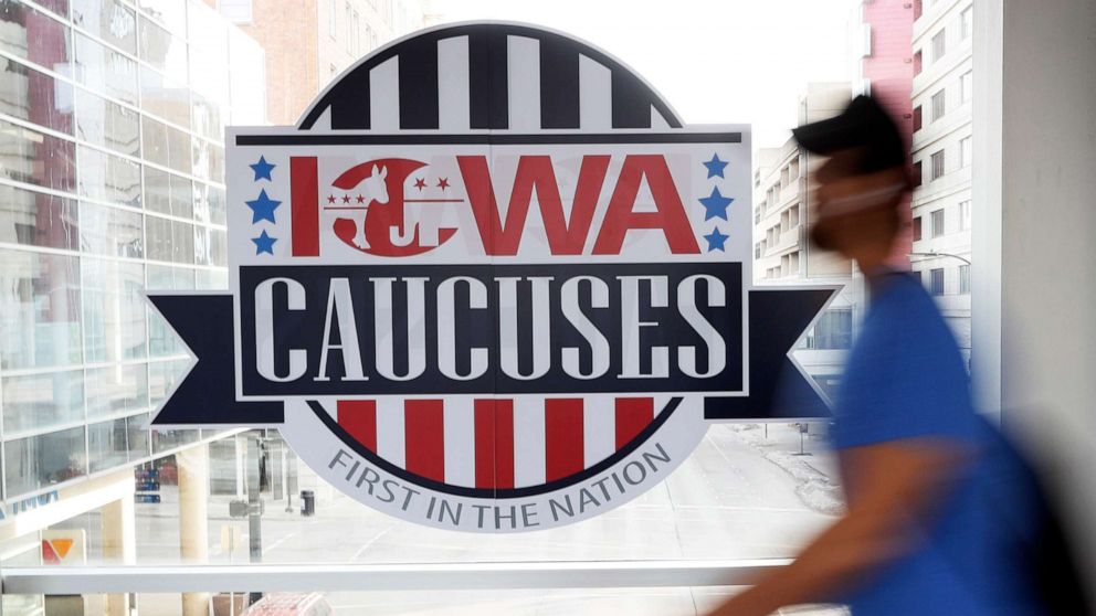 PHOTO: A pedestrian walks past a sign for the Iowa Caucuses on a downtown skywalk, in Des Moines, Iowa, Feb. 4, 2020. 