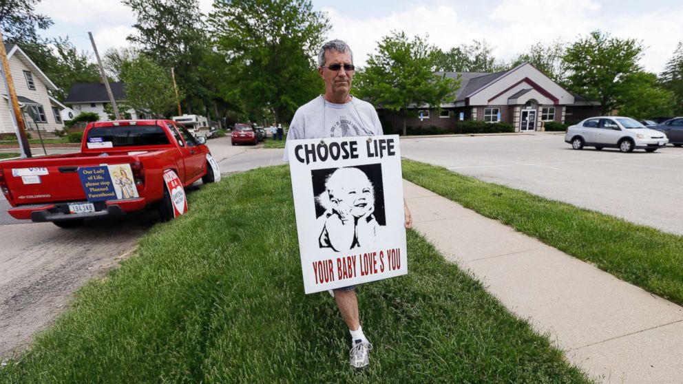 PHOTO: Coalition for Life of Iowa member Ron Digmann walks in front of the Planned Parenthood clinic, May 21, 2013, in Cedar Rapids, Iowa.