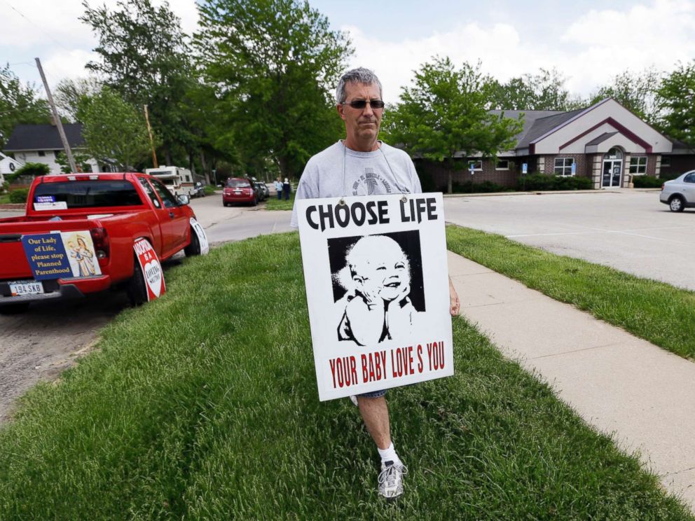 PHOTO: Coalition for Life of Iowa member Ron Digmann walks in front of the Planned Parenthood clinic, May 21, 2013, in Cedar Rapids, Iowa.