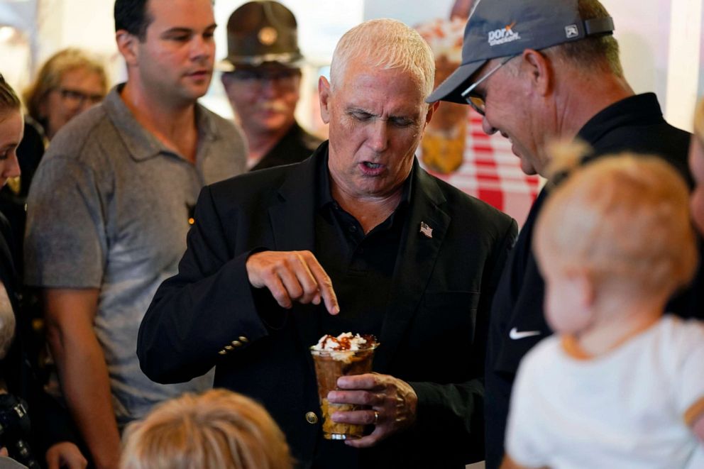 PHOTO: Former Vice President Mike Pence points out a picnic of pork at a cup at the Iowa Pork Producers tent during a visit to the Iowa State Fair, August 19, 2022, in Des Moines, Iowa.