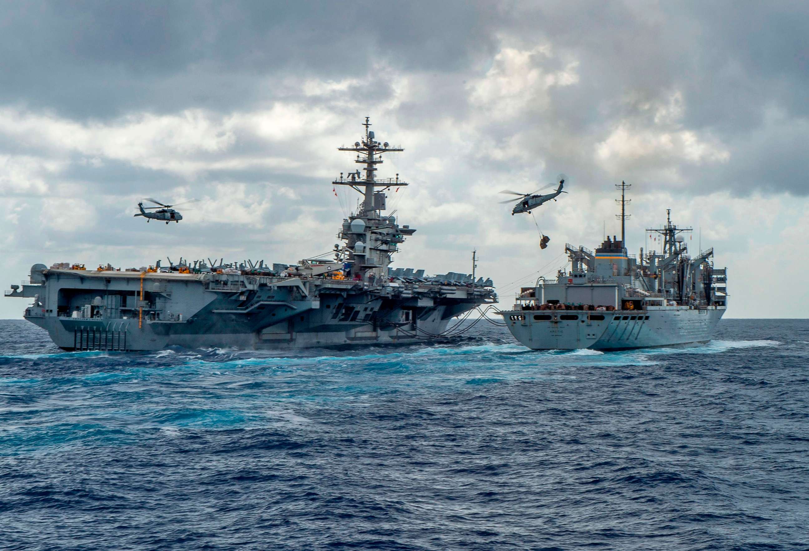 PHOTO: The USS Abraham Lincoln and USNS Arctic are pictured as helicopters transfer stores between the ships, May 8, 2019. The US is deploying ships and bombers to the Gulf, to put pressure on Iran. 