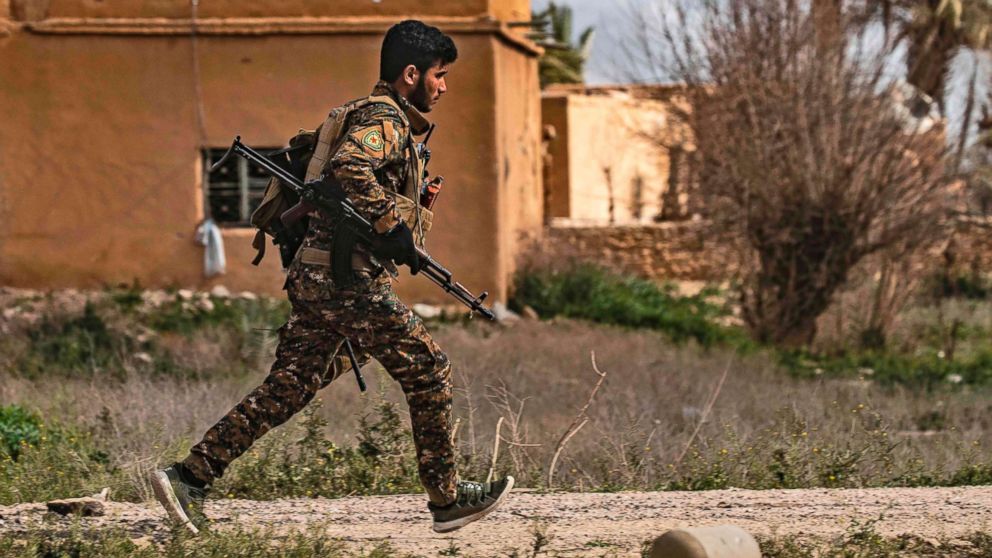 PHOTO: A member of the Syrian Democratic Forces (SDF) runs for cover during shelling on the Islamic State group's last holdout of Baghouz, in the eastern Syrian Deir Ezzor province, March 3, 2019.