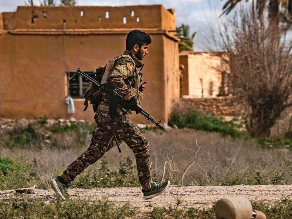 PHOTO: A member of the Syrian Democratic Forces (SDF) runs for cover during shelling on the Islamic State groups last holdout of Baghouz, in the eastern Syrian Deir Ezzor province, March 3, 2019.