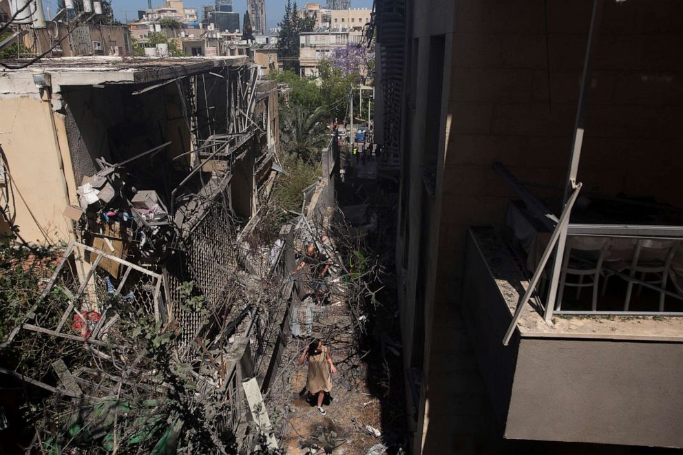 PHOTO: A woman walks through the rubble where a rocket launched from the Gaza strip hit her house, May 12, 2021 in Giv'atayim, Israel.