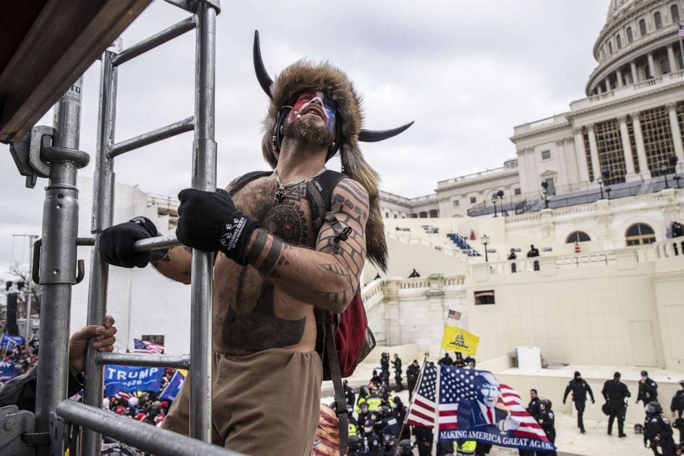 PHOTO: Jacob Chansley climbs scaffolding as demonstrators swarm the U.S. Capitol building in Washington, D.C., Jan. 6, 2021.