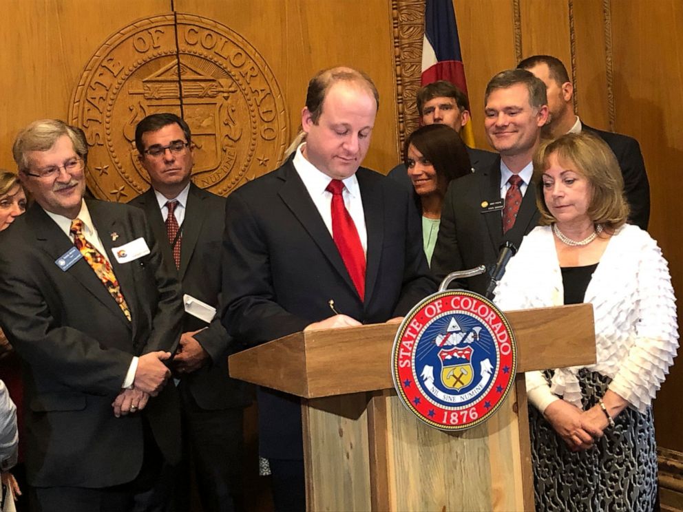 PHOTO: Colorado Gov. Jared Polis, at podium, signs into law Senate Bill 19-181 at the State Capitol in Denver, Colo., Tuesday, April 16, 2019.