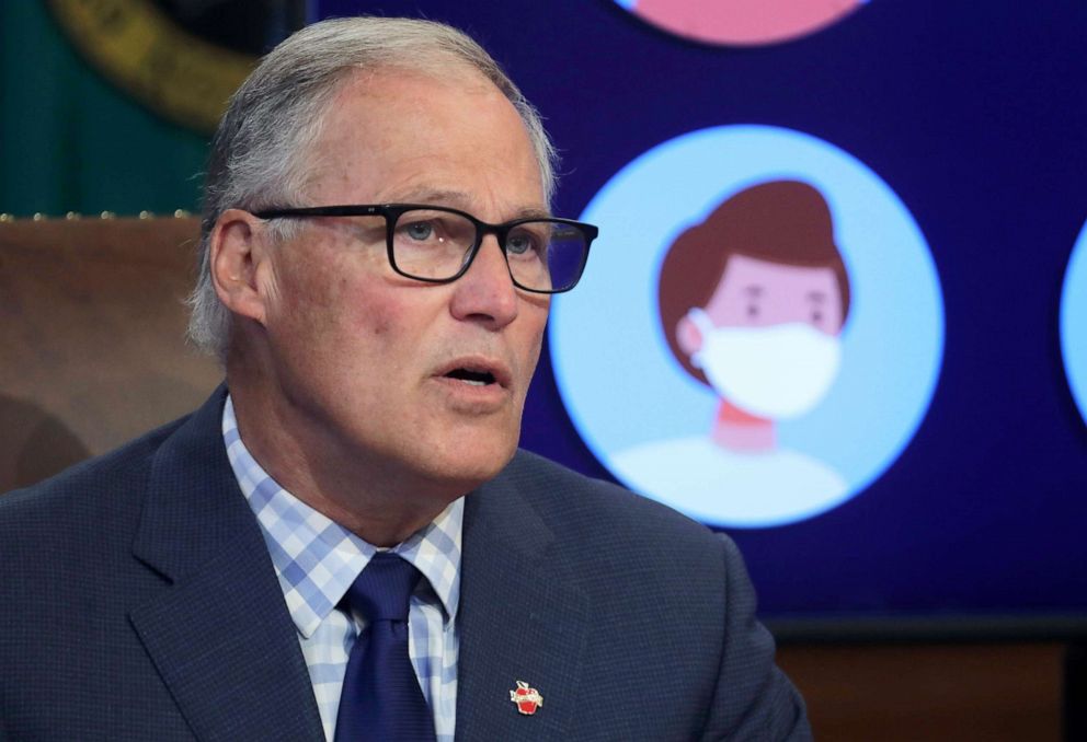 PHOTO: Washington Gov. Jay Inslee speaks next to a video display showing images of people wearing masks during a news conference, June 23, 2020, at the Capitol in Olympia, Wash.