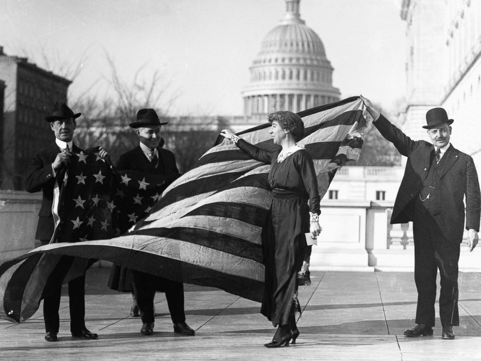 PHOTO: Congresswoman Jeannette Rankin is presented with the flag that flew at the House of Representatives during the passage of the suffrage amendment, circa Jan. 21, 1918.