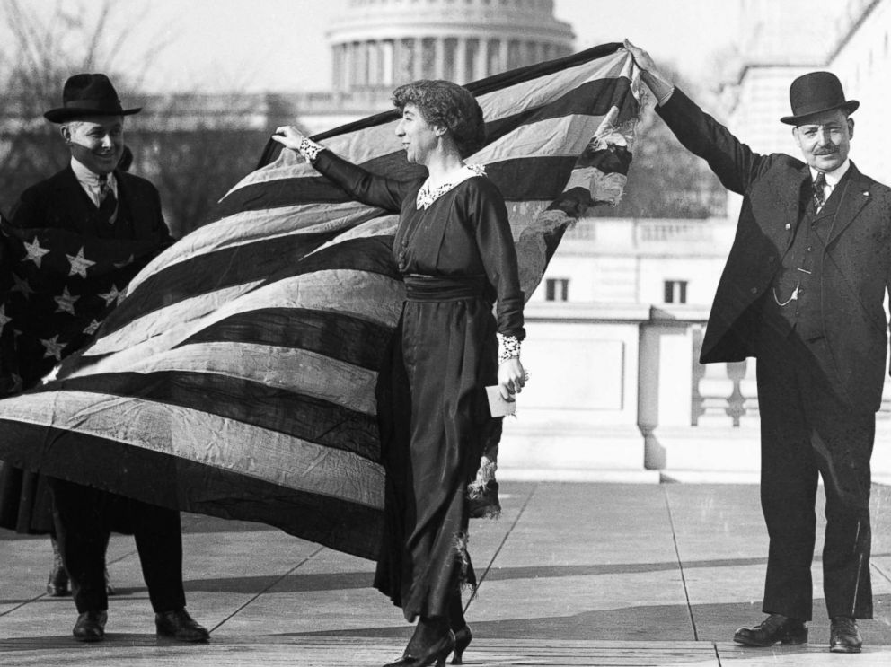 PHOTO: Congresswoman Jeannette Rankin is presented with the flag that flew at the House of Representatives during the passage of the suffrage amendment, circa Jan. 21, 1918.