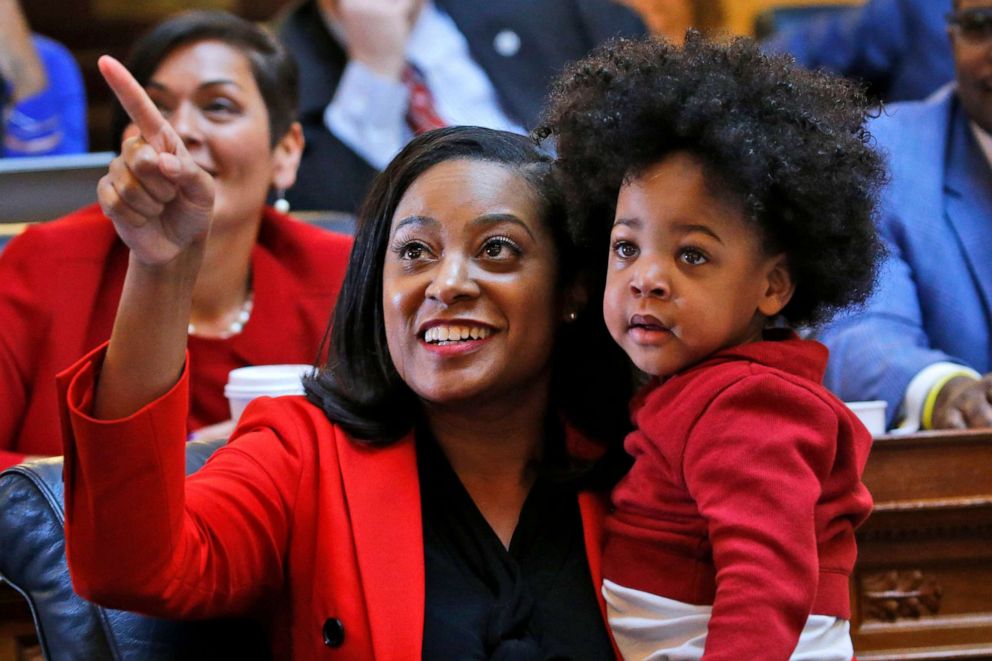 PHOTO: Del. Jennifer Carroll Foy holds her son, Alex Foy, while pointing out the vote tally board for the vote on the Equal Rights Amendment in the House chambers at the Capitol in Richmond, Va., Jan. 27, 2020.