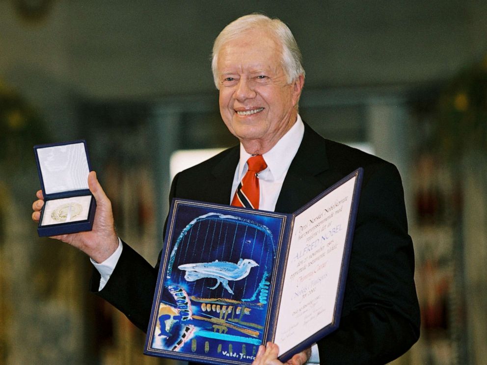 PHOTO: Former President Jimmy Carter holds up his Nobel Peace Prize, Dec. 10, 2002, in Oslo, Norway.