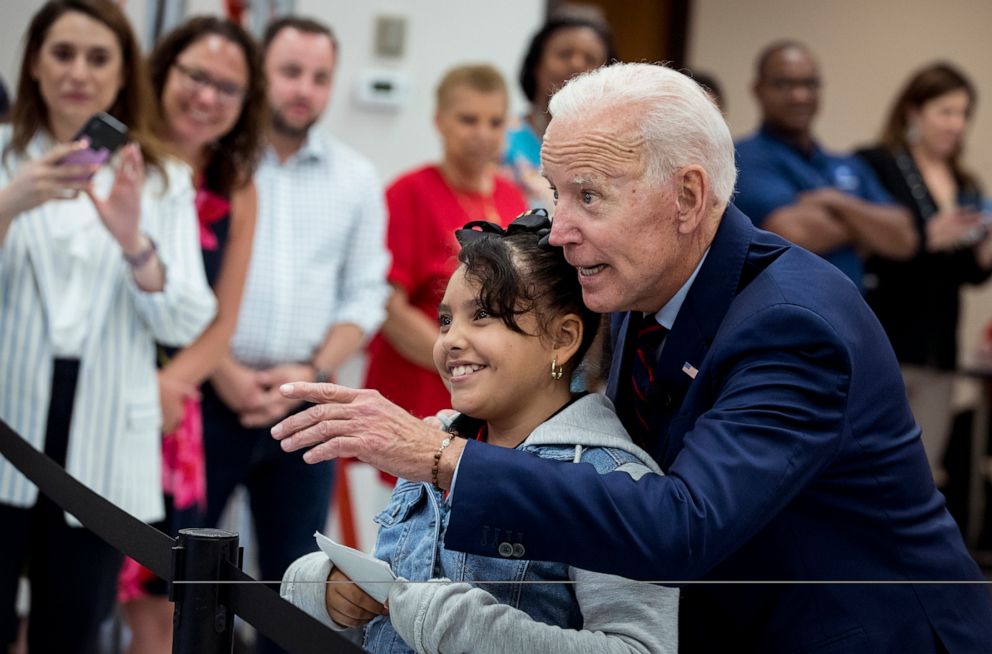 PHOTO: Former Vice President Joe Biden takes Virmania Villalobos, 10, back to introduce her to members of the media during a town all meeting with a group of educators from the American Federation of Teachers, May 28, 2019, in Houston.