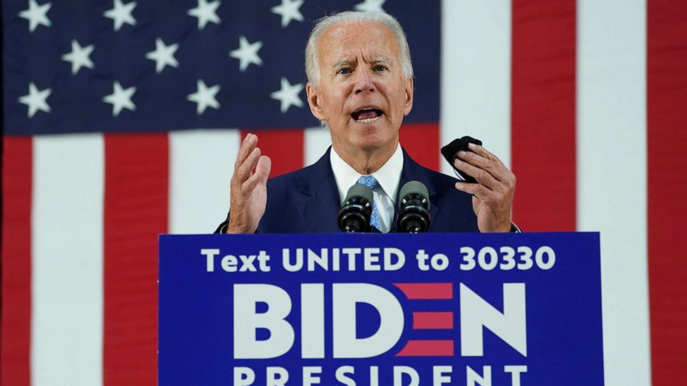 PHOTO: Former Vice President Joe Biden holds his protective face mask as he speaks about the Trump administration's handling of the coronavirus pandemic during a campaign event in Wilmington, Del., June 30, 2020.
