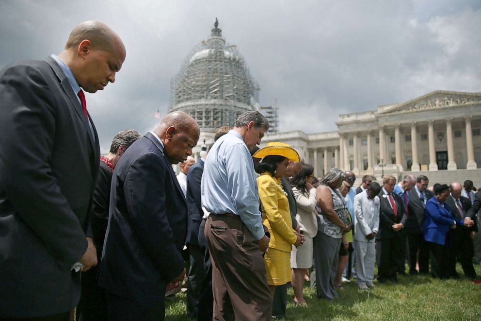 PHOTO: Sen. Cory Booker, Rep. John Lewis and Sen. Joe Manchin pray with other members of Congress to honor those gunned down inside the historic Emanuel African Methodist Episcopal Church in Charleston, S.C., June 18, 2015, in Washington.