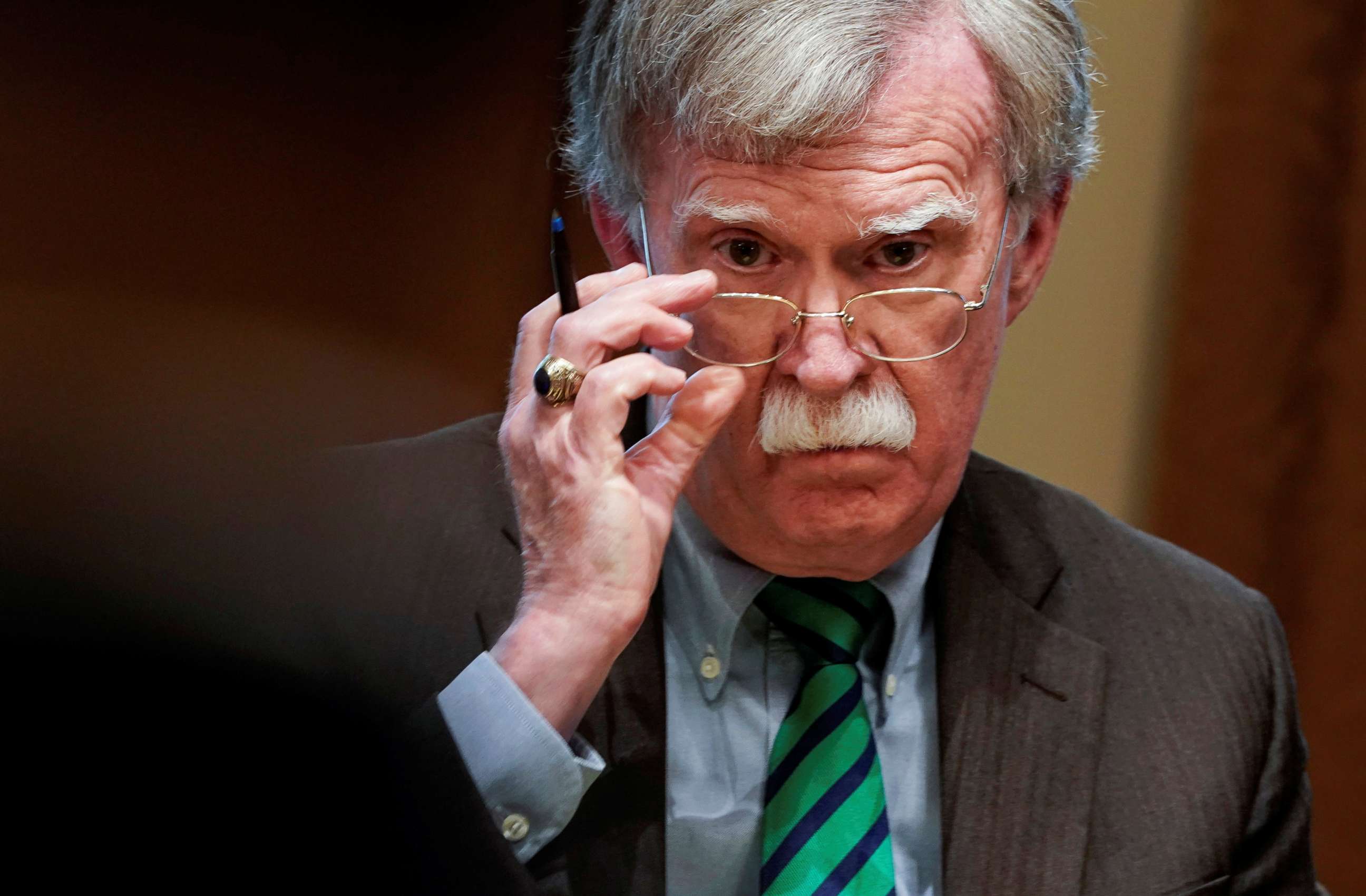 PHOTO: National security adviser John Bolton adjusts his glasses as President Donald Trump speaks while meeting with NATO Secretary General Jens Stoltenberg in the Oval Office at the White House in Washington, April 2, 2019.