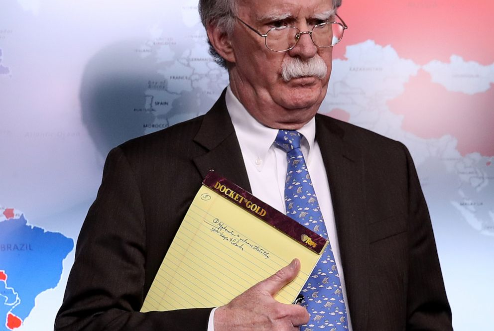 PHOTO: National Security Advisor John Bolton listens to questions from reporters during a press briefing at the White House, Jan. 28, 2019, while holding a legal pad with handwritten notes.