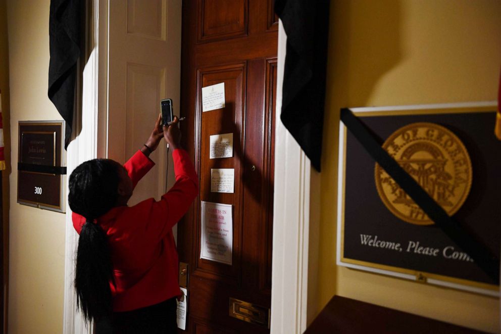 PHOTO: A woman takes a photo with her cellphone of notes left at the office door of Rep. John Lewis who died July 18, 2020, at age 80, at the U.S. Capitol on July 20, 2020, in Washington.