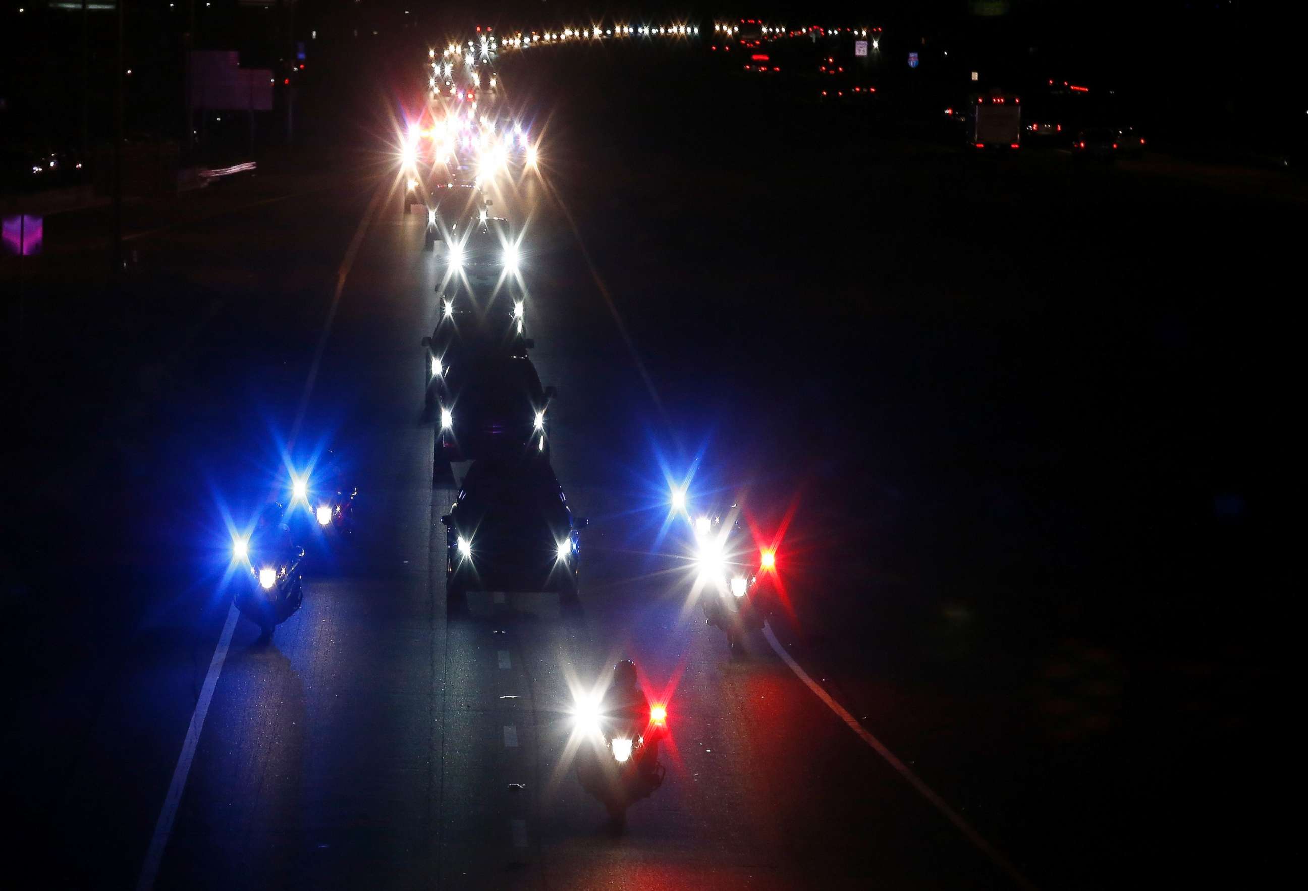 PHOTO: With a police escort, a long procession follows the hearse carrying the late Arizona Sen. John McCain, along Interstate 17 en route to Phoenix, Aug. 25, 2018, in Anthem, Ariz.
