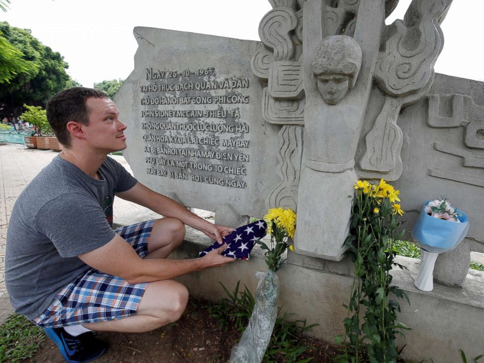 PHOTO: English teacher Derek Davis from the U.S. places an American flag and flowers in memory of the late Senator John McCain at the McCain Memorial in Hanoi, Vietnam, Aug. 26, 2018.