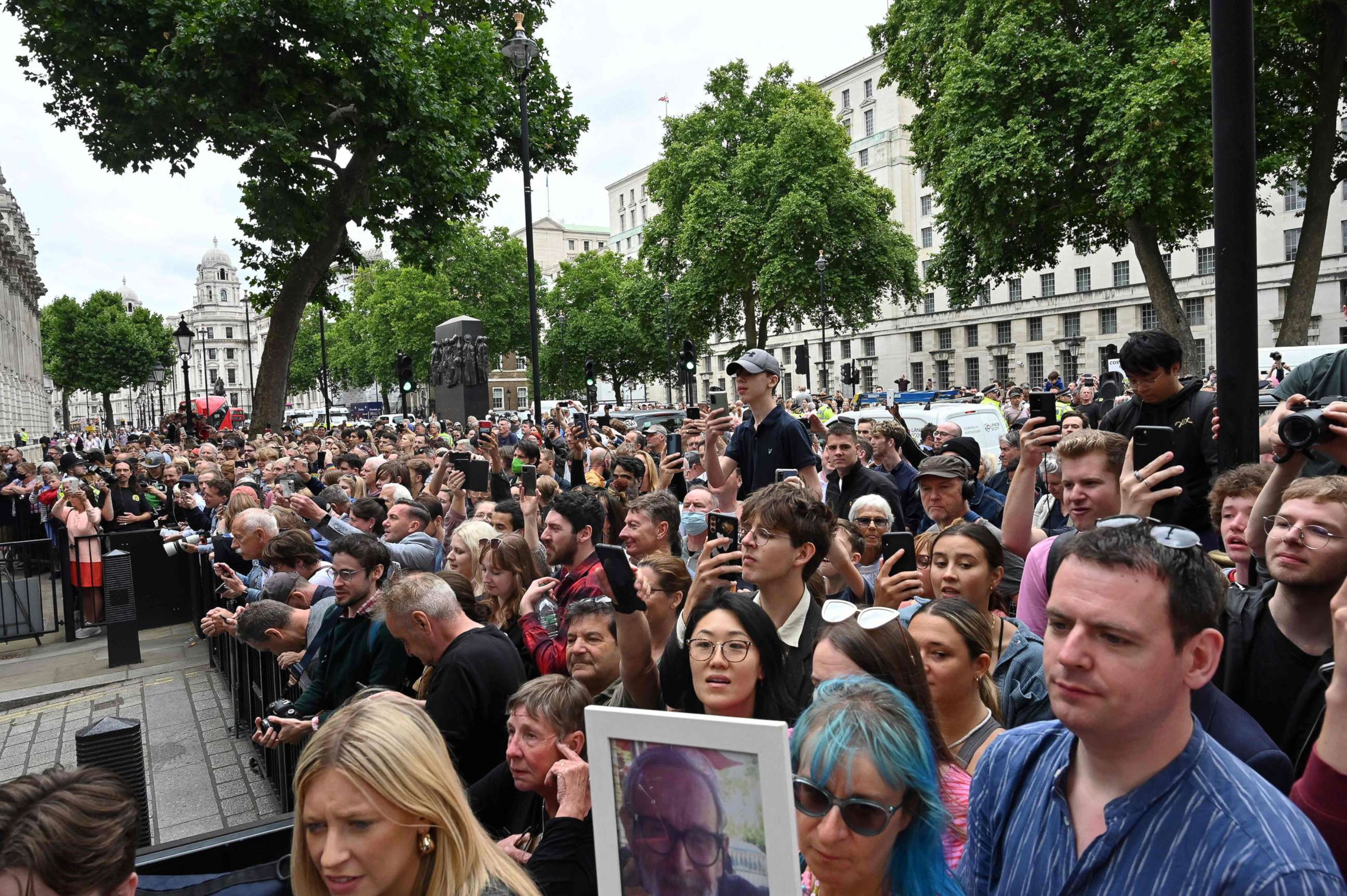 PHOTO: Members of the public wait outside the gates of Downing Street after Britain's Prime Minister Boris Johnson made a statement about his resignation in front of Number 10 in London, July 7, 2022.