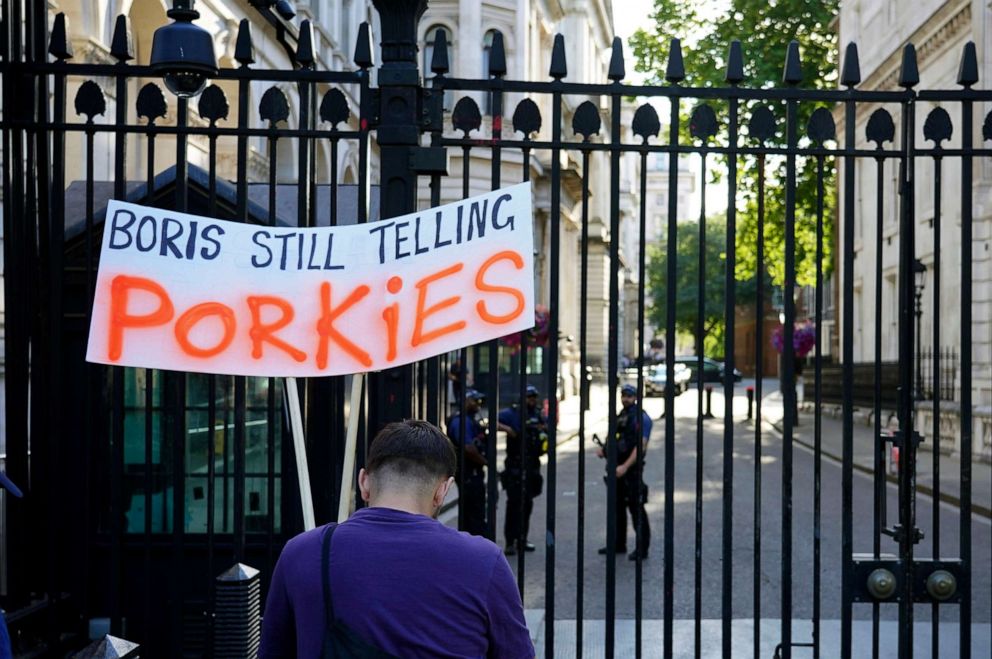 PHOTO: A protester holds a sign reading, "Boris still telling porkies" outside the gates to Downing Street following the resignation of two senior cabinet ministers, in London, July 5, 2022.