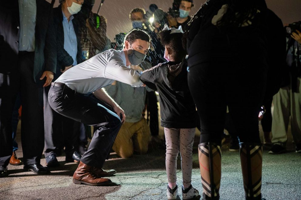 PHOTO: Democratic Senate candidate Jon Ossoff bumps elbows with a young supporter at a campaign event on Nov. 10, 2020, in Atlanta.