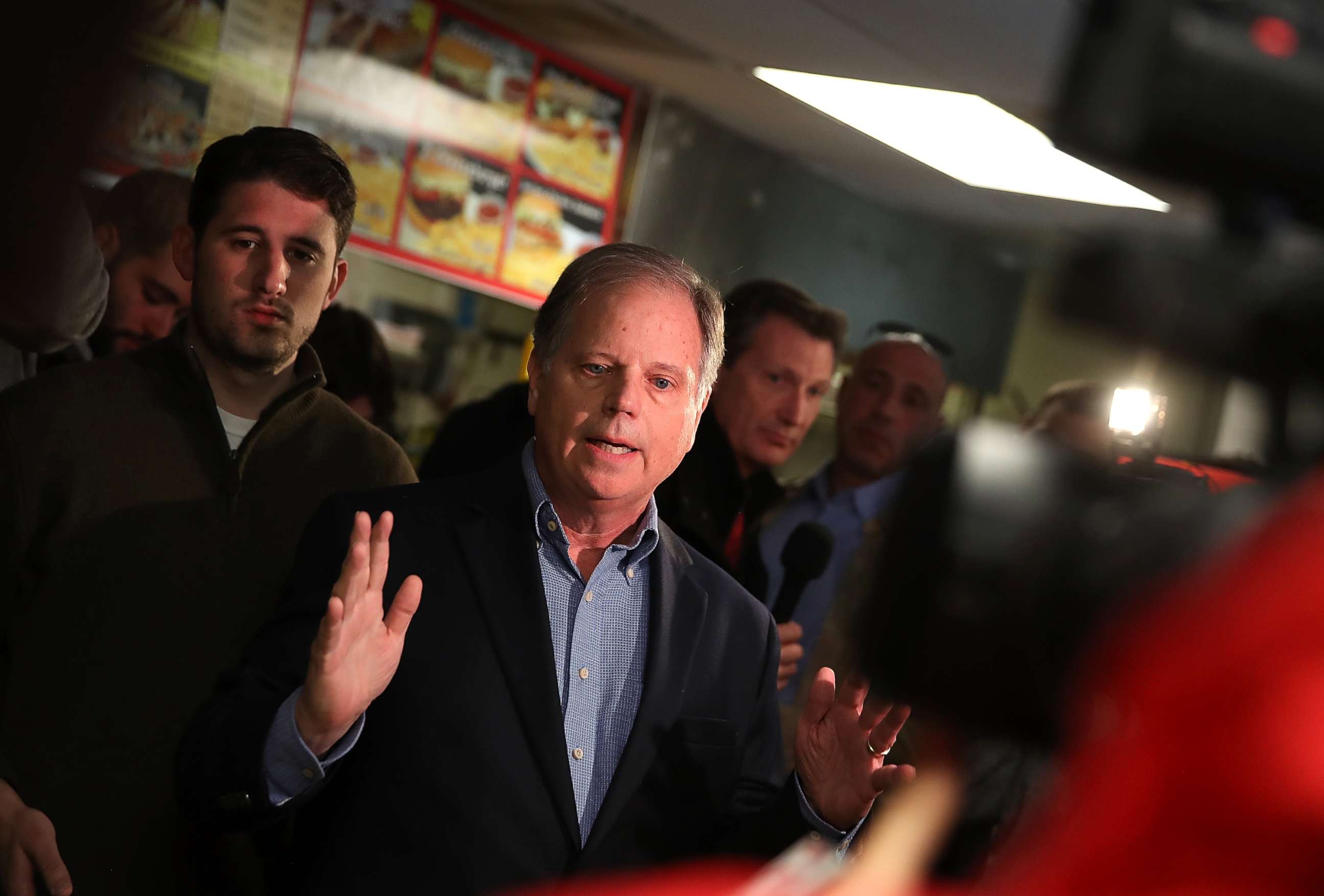 PHOTO: Doug Jones talks with reporters during a campaign stop at restaurant Chris Z's, Dec. 11, 2017, in Birmingham, Ala.