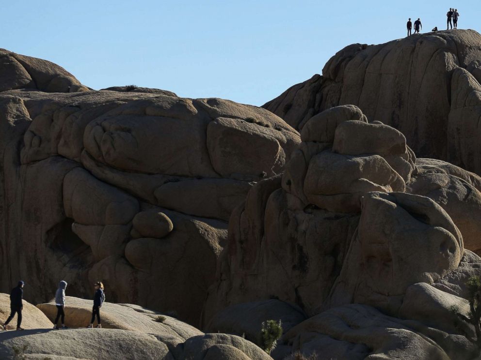 PHOTO: Visitors walk atop rock formations at Joshua Tree National Park on Jan. 4, 2019, in Joshua Tree National Park, Calif.