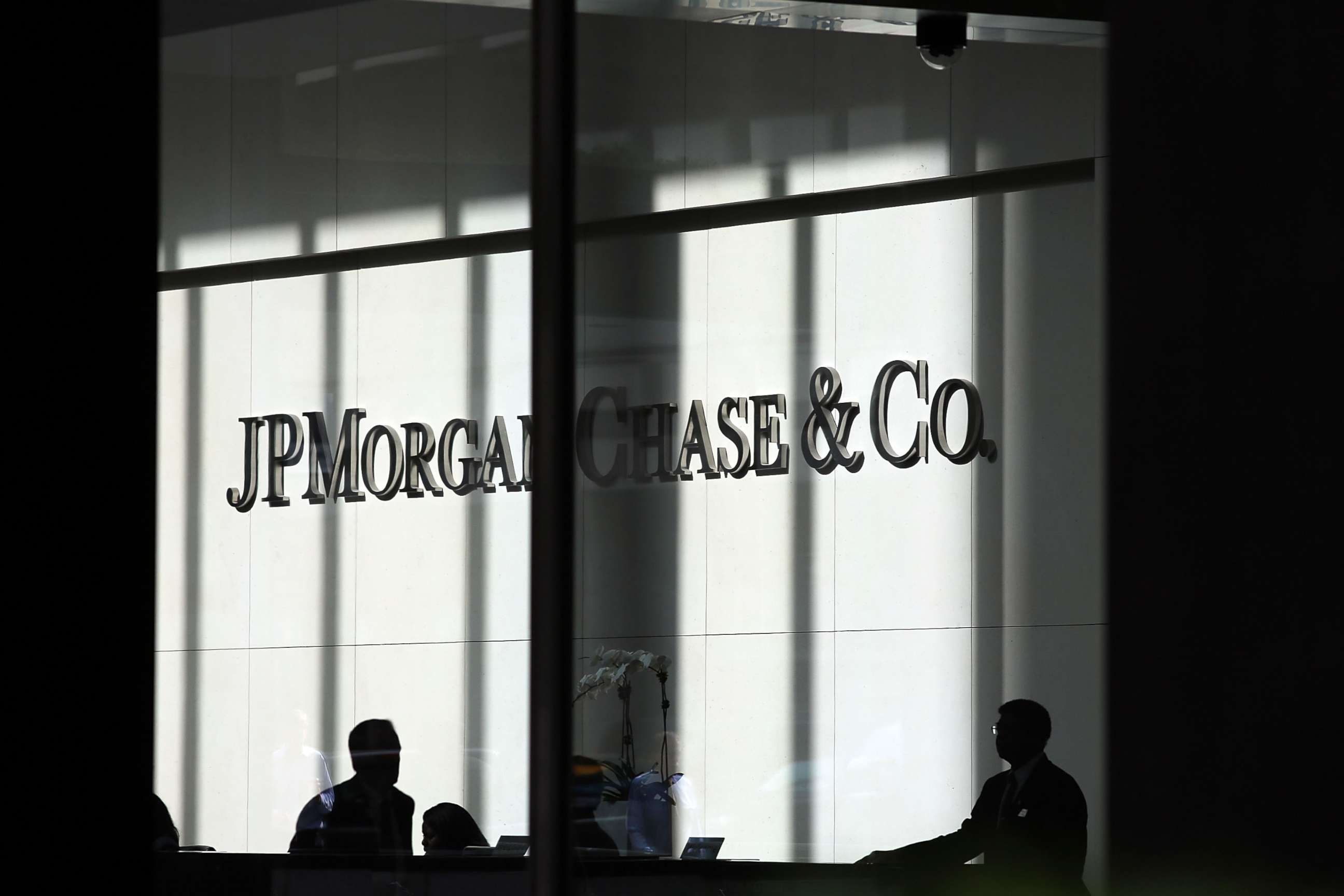 PHOTO: People pass a sign for JPMorgan Chase & Co. at it's headquarters in Manhattan, Oct. 2, 2012 in New York City.