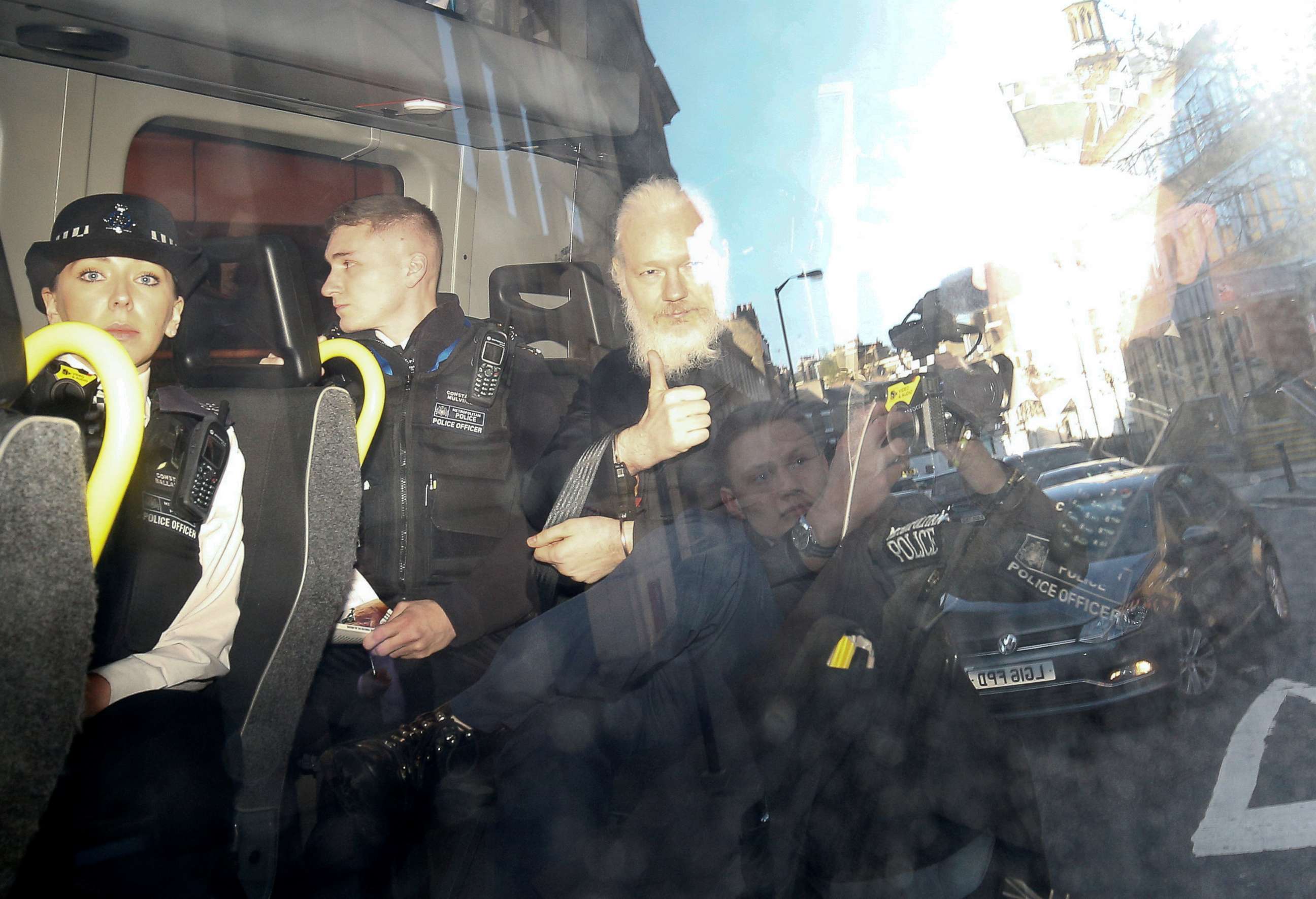 PHOTO: WikiLeaks founder Julian Assange gestures as he leaves the Westminster Magistrates Court in the police van, after he was arrested in London, April 11, 2019.