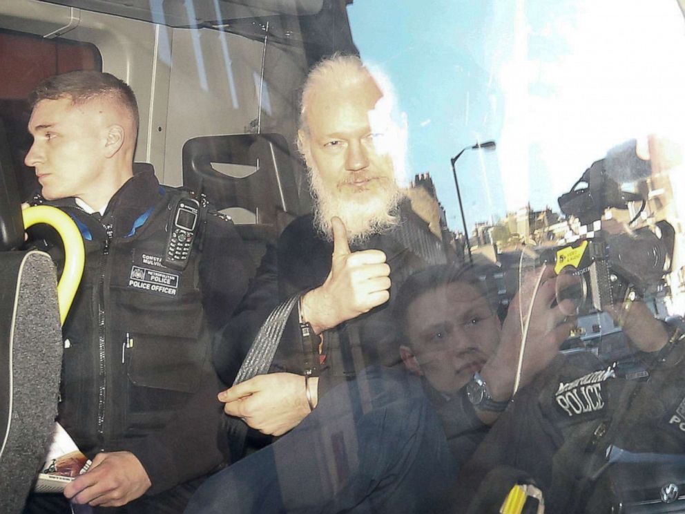 PHOTO: WikiLeaks founder Julian Assange gestures as he leaves the Westminster Magistrates Court in the police van, after he was arrested in London, April 11, 2019.