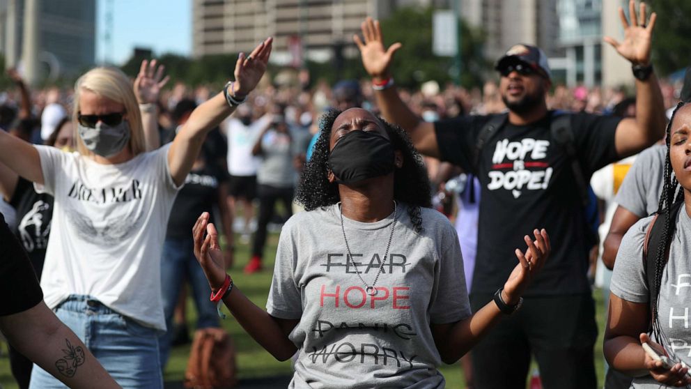 PHOTO: People pray together during a Juneteenth event at Centennial Olympic Park on June 19, 2020, in Atlanta.