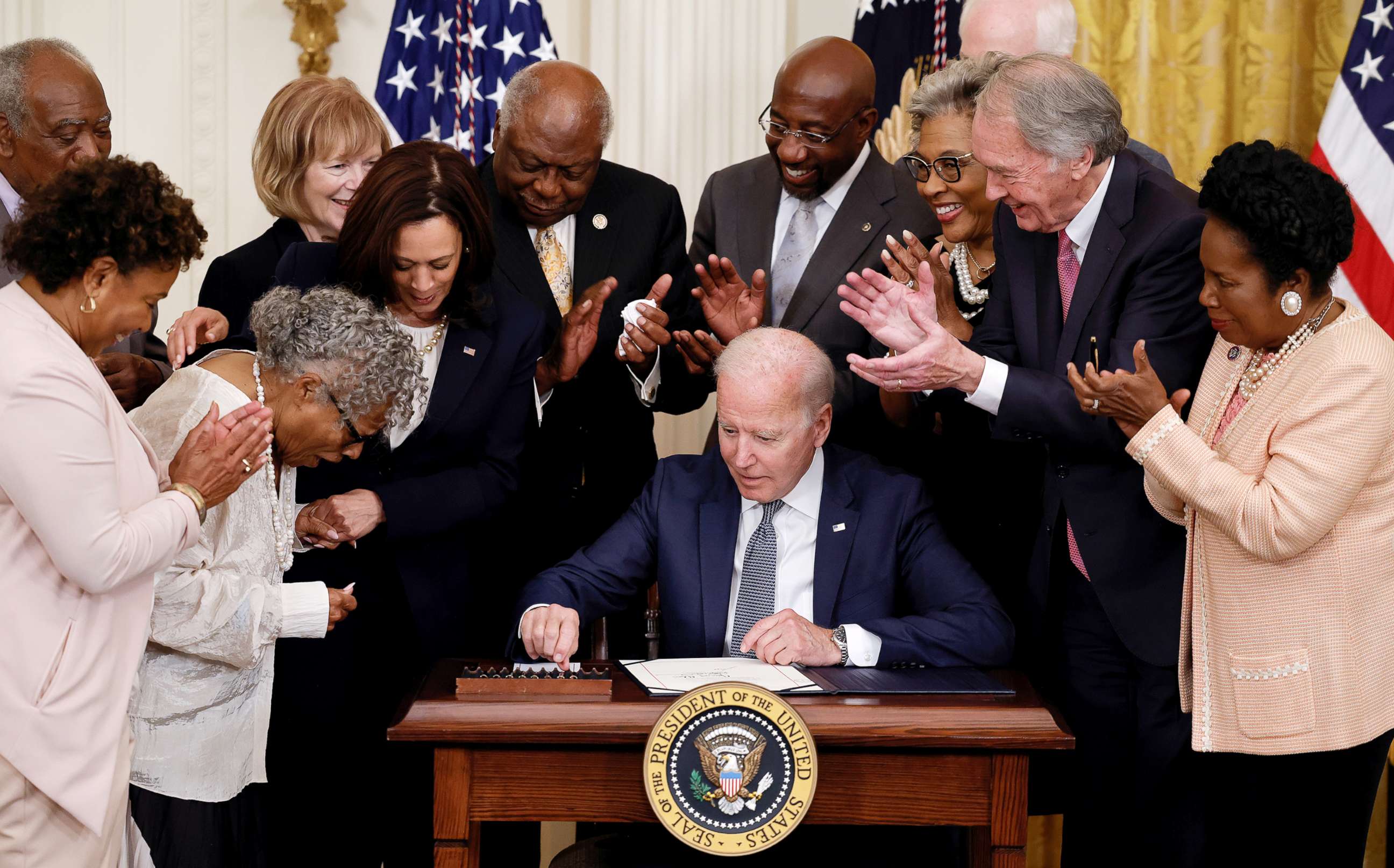 PHOTO: President Joe Biden is applauded as he reaches for a pen to sign the Juneteenth National Independence Day Act into law as Vice President Kamala Harris stands by in the East Room of the White House June 17, 2021. 
