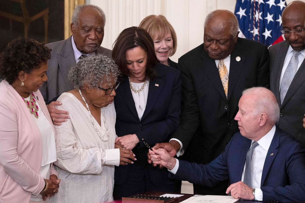 PHOTO: Vice President Kamala Harris watches as Opal Lee (2nd L), the activist known as the grandmother of Juneteenth, is given a pen after President Joe Biden signs the Juneteenth National Independence Day Act, in the White House, June 17, 2021.