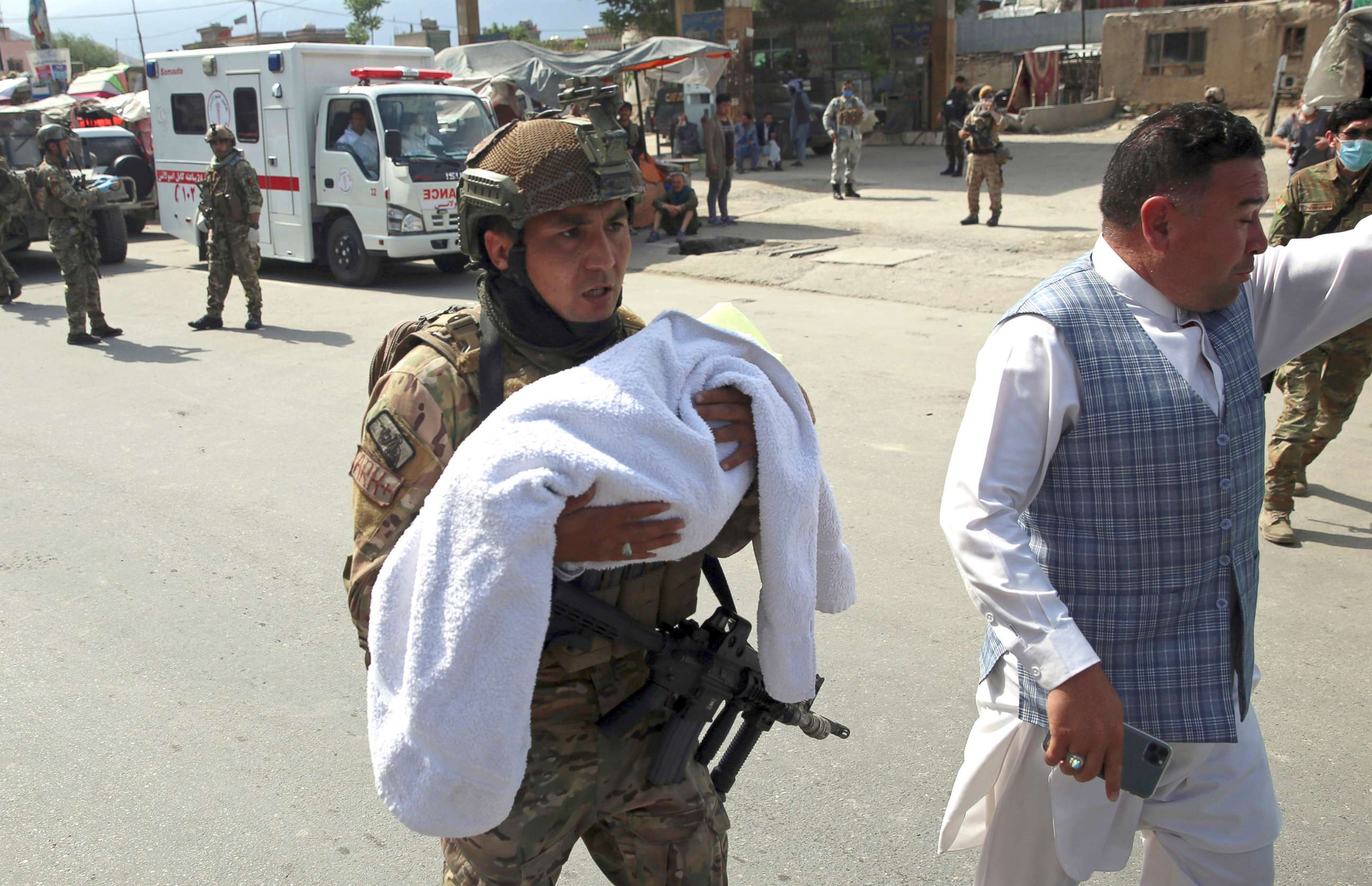 PHOTO: An Afghan security officer carries a baby after gunmen attacked a maternity hospital, in Kabul, Afghanistan, May 12, 2020. 