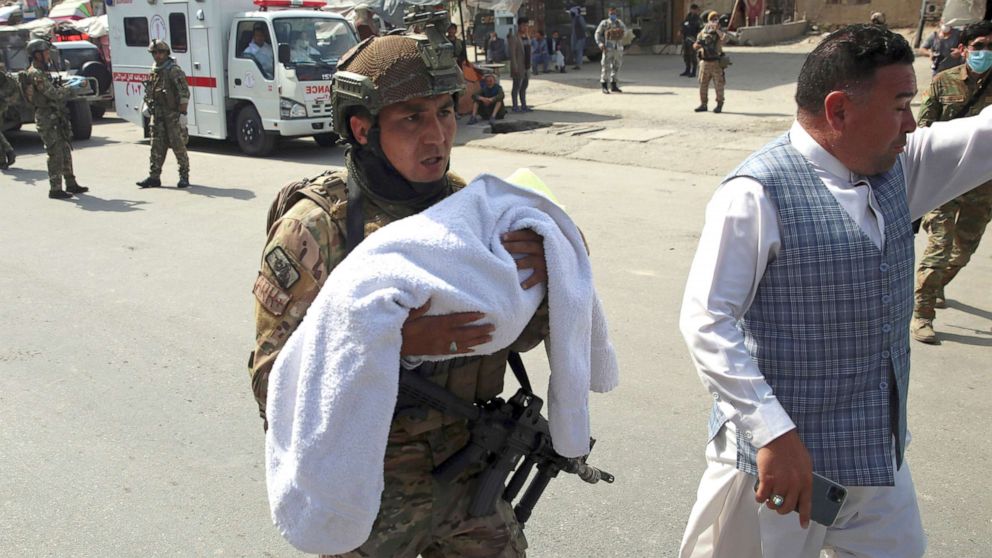 PHOTO: An Afghan security officer carries a baby after gunmen attacked a maternity hospital, in Kabul, Afghanistan, May 12, 2020. 