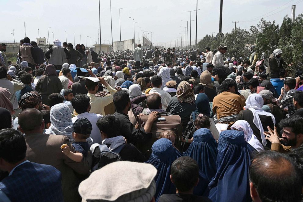 PHOTO: Afghans gather on a roadside near the military part of the airport in Kabul, Aug. 20, 2021, hoping to flee from the country after the Taliban's military takeover of Afghanistan.