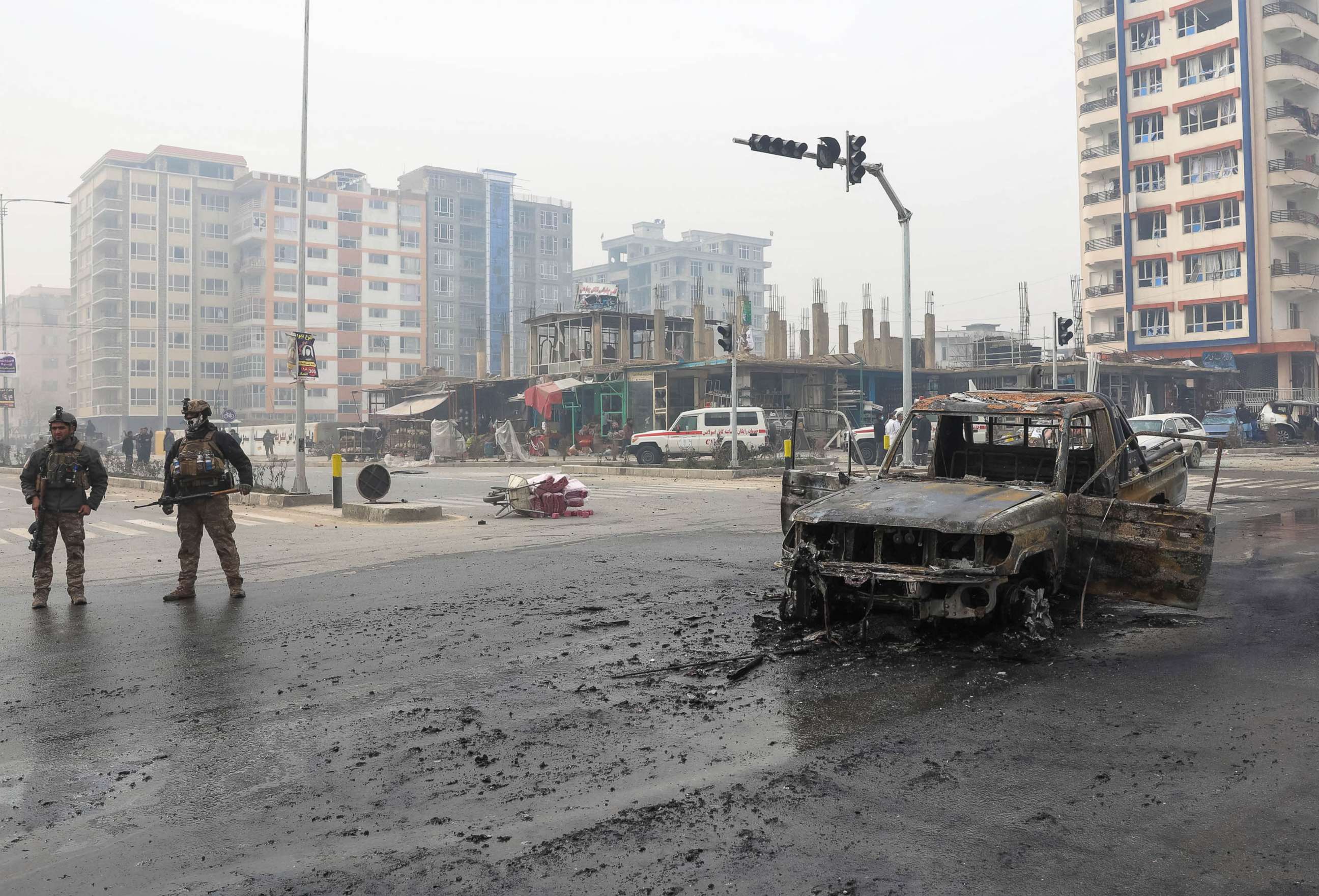 PHOTO: A charred vehicle sits in the road as Afghan security forces inspect the site of a bomb explosion in Kabul, Afghanistan, Dec. 20, 2020.