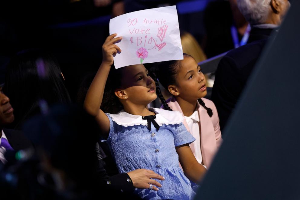 PHOTO: Vice President Kamala Harris' grandnieces Amara (R) and Leila (L) listen as Democratic presidential candidate, U.S. Vice President Kamala Harris speaks on stage on Day 4 of the Democratic National Convention Aug. 22, 2024 in Chicago.